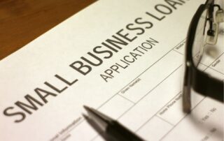 Pen lying on a form with the words Small Business Loan application.